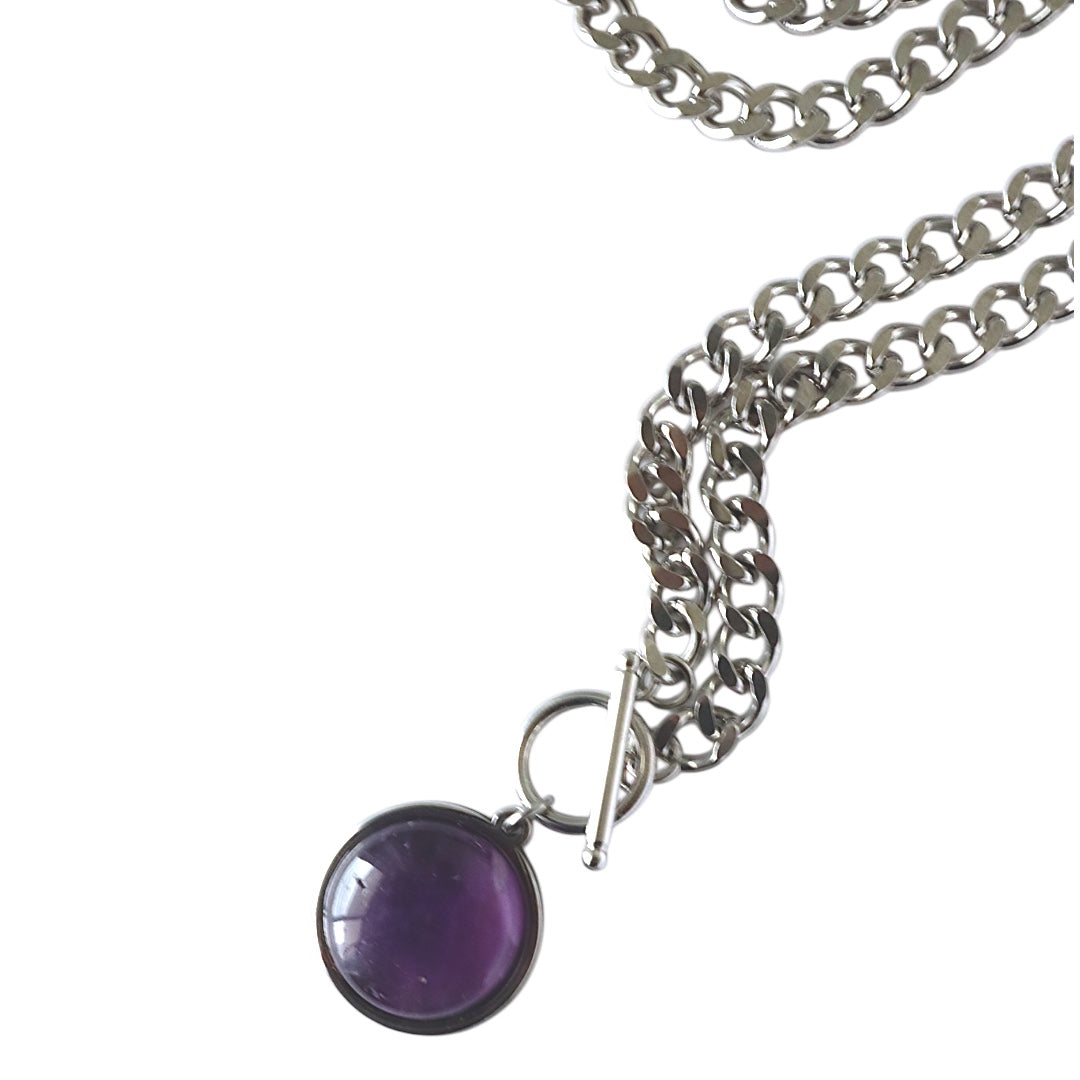 Silver chain necklace with a purple pendant on a white background