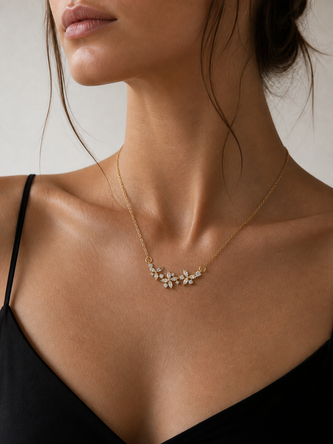 Necklace with floral design worn by a model against a neutral background