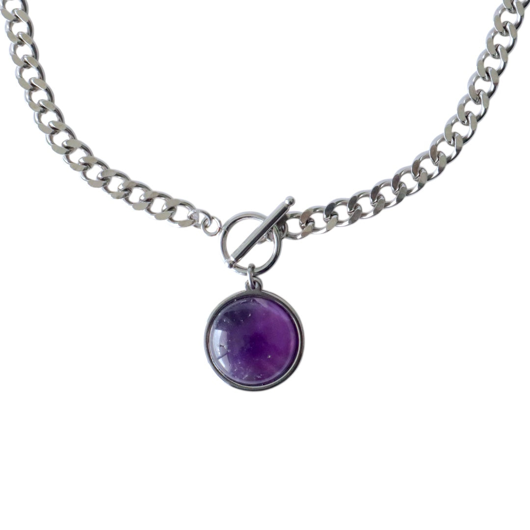 A silver-colored chain necklace with a circular purple pendant.