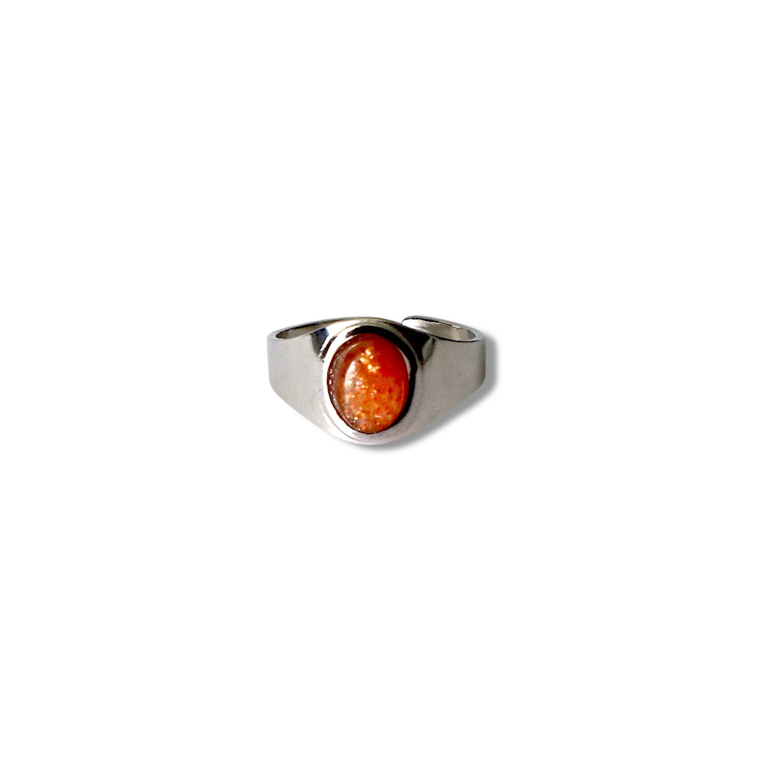 A stainless steel ring with a silver finish featuring an orange radiant gemstone.