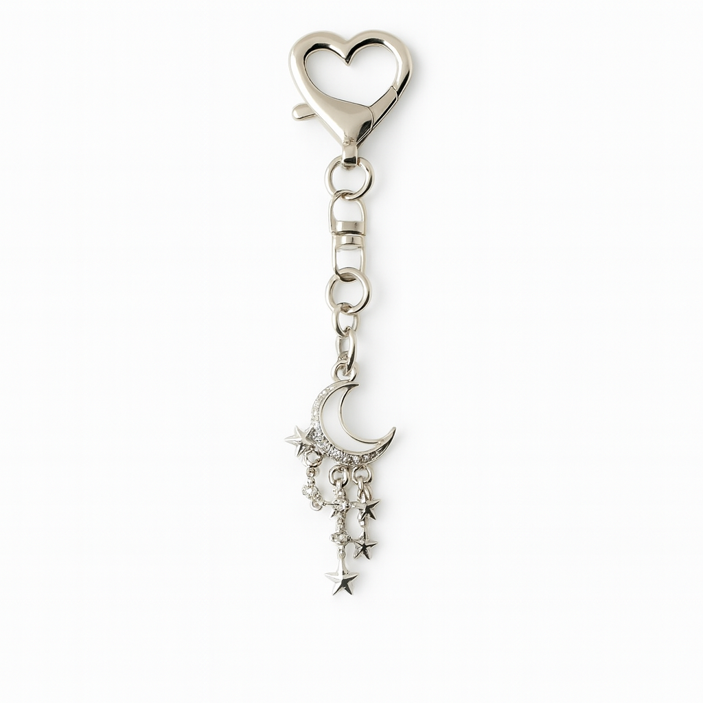 Silver keychain with heart-shaped clasp and moon, star, and diamond charm on a white background