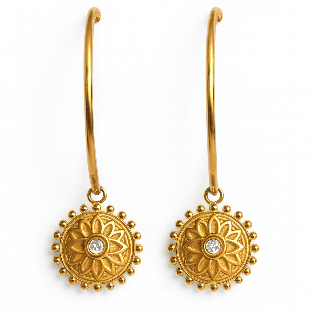 Gold earrings with floral designs and clear stones on a white background