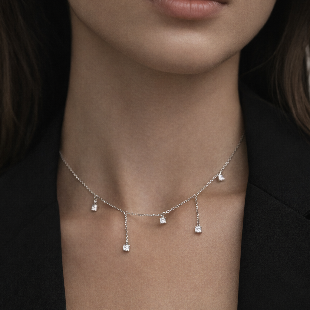 Necklace with small diamond pendants on a person wearing a black blazer.