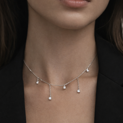 Necklace with small diamond pendants on a person wearing a black blazer.