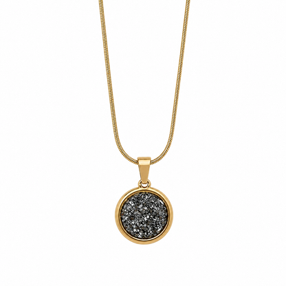 Gold necklace with a round pendant featuring black druzy on a white background