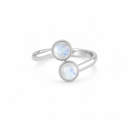 Silver ring with two round moonstone gemstones on a white background
