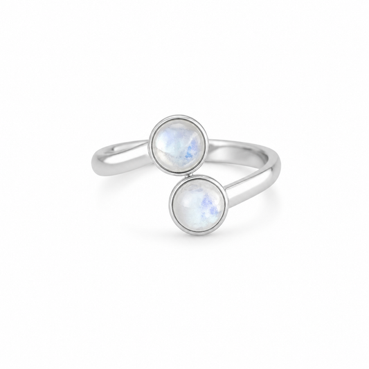 Silver ring with two round moonstone gemstones on a white background