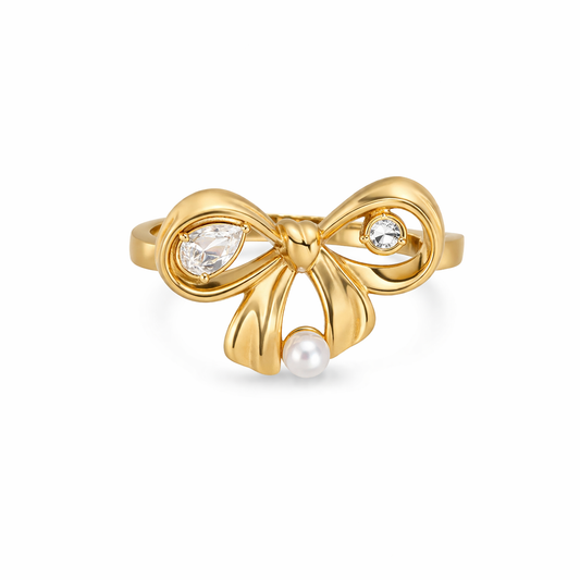 Gold bow-shaped ring with gemstones on a white background