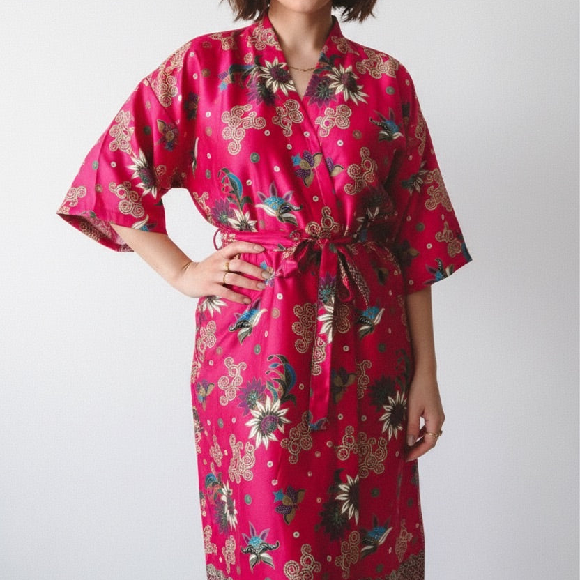Person wearing a pink floral kimono-style robe on a white background