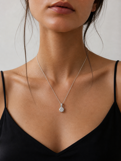 Necklace with a diamond pendant worn by a person against a neutral background