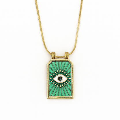 Gold necklace with a green pendant featuring an eye design on a white background