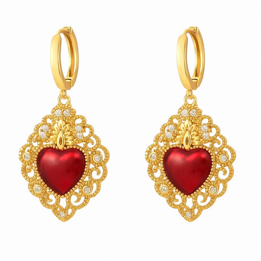 Gold earrings with red heart charms on a white background
