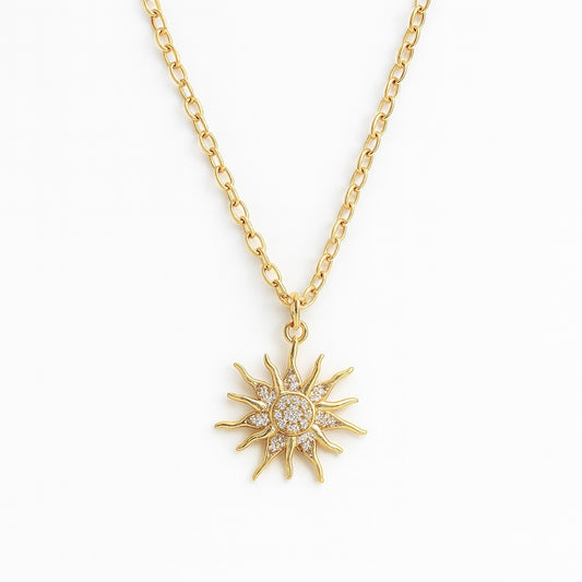 Gold sun-shaped pendant necklace on a white background