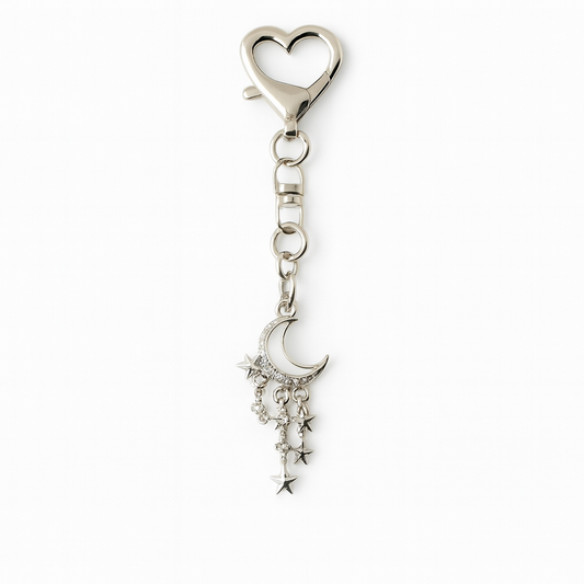 Silver keychain with heart-shaped clasp and moon, star, and diamond charm on a white background