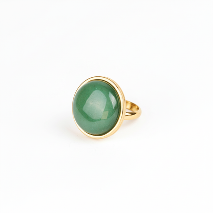 Gold ring with a green gemstone on a white background