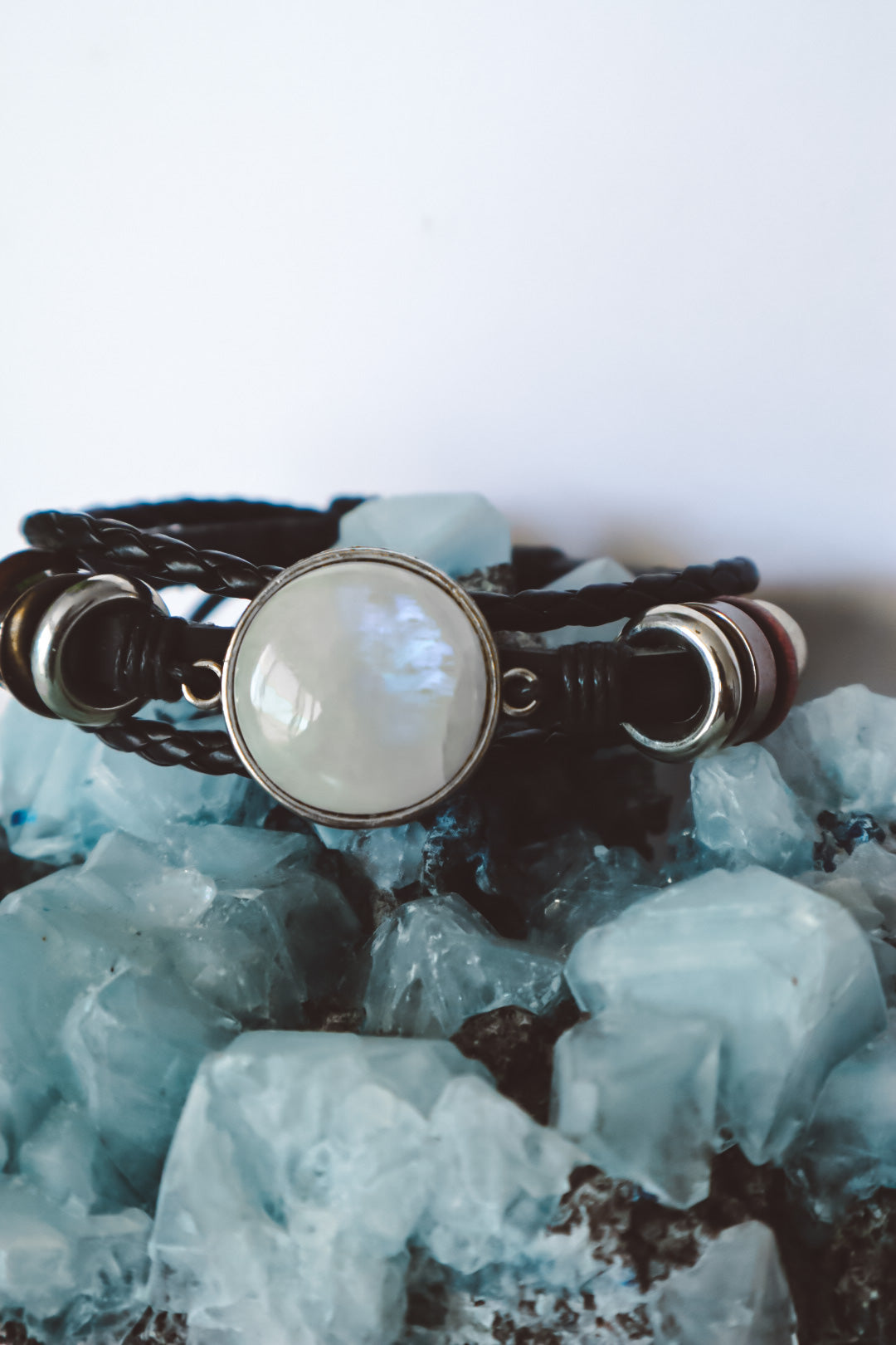 "Boho-inspired Rainbow Moonstone Beaded Stack Bracelet featuring a 20mm AAA-grade moonstone on an adjustable braided bracelet with beads and faux leather."