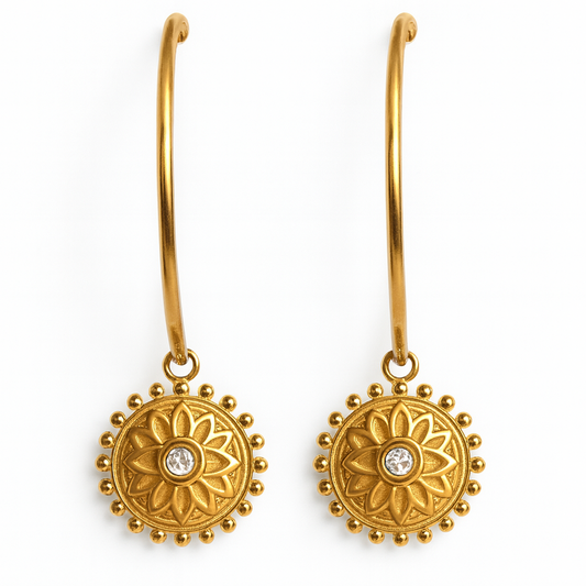 Gold earrings with floral designs and clear stones on a white background