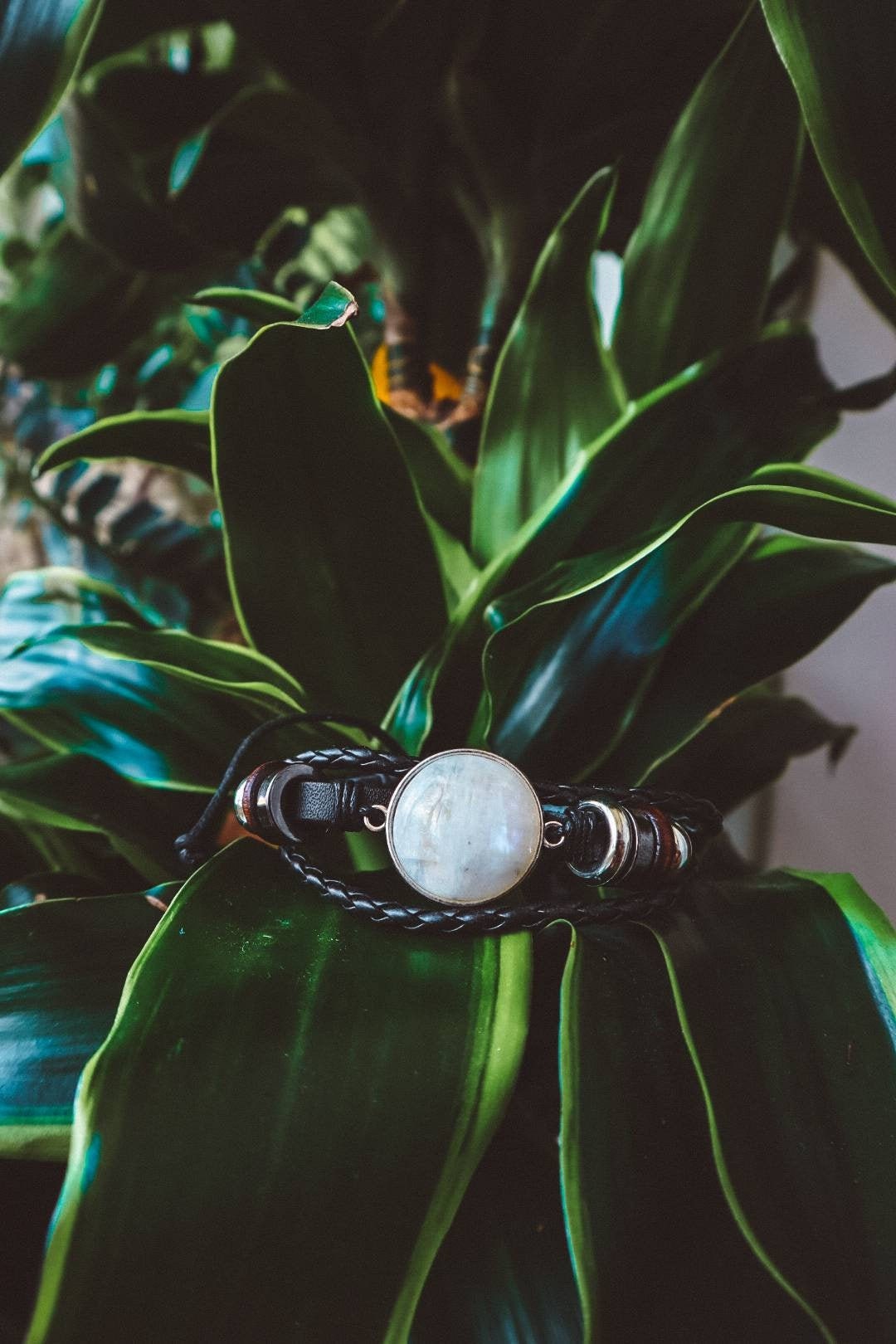 "Boho-inspired Rainbow Moonstone Beaded Stack Bracelet featuring a 20mm AAA-grade moonstone on an adjustable braided bracelet with beads and faux leather."